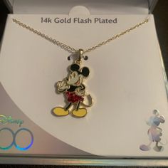 a necklace with a mickey mouse charm on it's chain in a gift box