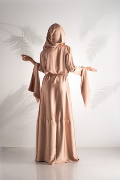 "Embrace opulence and refinement with our Blush Elegance Enshrouded Abaya. This luxurious hooded dress is a testament to style and sophistication, boasting a captivating design that's nothing short of extraordinary. The delicate blush color exudes grace and femininity, while the meticulously crafted details and luxurious embellishments create an aura of pure grandeur. Perfect for special occasions or when you simply want to radiate elegance, the Blush Elegance Enshrouded Abaya will make a lastin Floor-length Beige Abaya For Eid, Long Beige Dress For Eid, Long Beige Dresses For Eid, Beige Long Dress For Eid, Elegant Long Beige Robe, Elegant Floor-length Khimar For Wedding, Elegant Tunic Maxi Dress For Eid, Elegant Long Beige Thobe, Elegant Beige Long Thobe