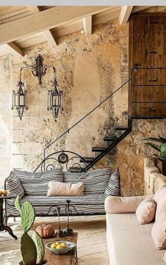 a living room filled with furniture next to a stone wall covered in potted plants