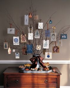 a table topped with a vase filled with flowers next to a wall covered in pictures