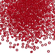 red beads are scattered on a white surface