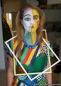 a woman with painted face and body standing in front of a mirror wearing a costume