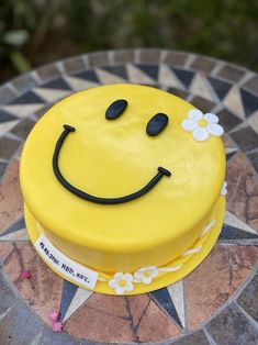 a smiley face cake sitting on top of a table