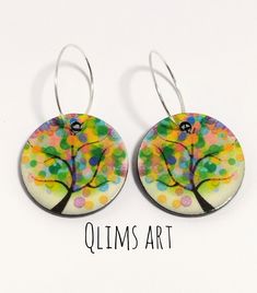 pair of colorful tree earrings on white background with words qlims art written below