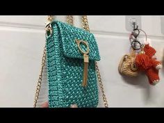 a handbag hanging on the wall with two key chains attached to it