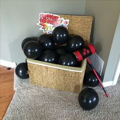 a basket filled with black balloons sitting on top of a carpet