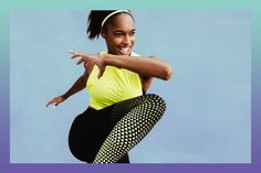 a woman in yellow shirt and black leggings doing a dance move with her arms out