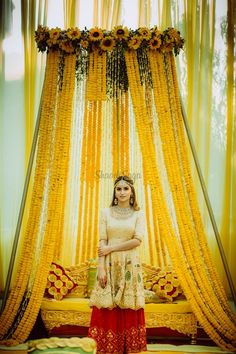 a woman standing in front of a yellow curtain