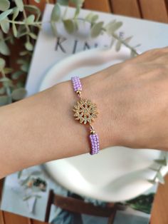 a woman's arm with a bracelet on it and a flower in the middle