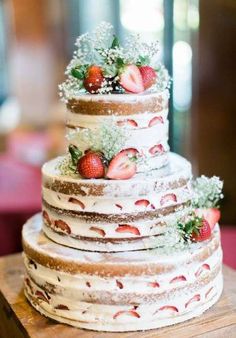 a three tiered cake with strawberries on top