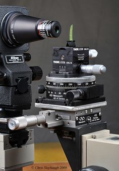 an old movie camera sitting on top of a tripod in front of a box