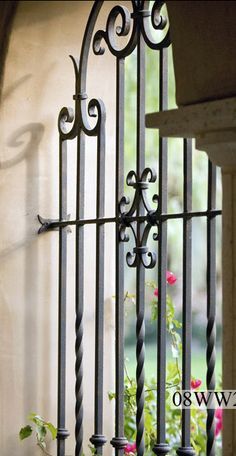 an iron gate with flowers growing through it