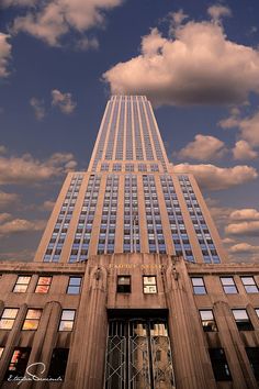 a very tall building sitting under a cloudy blue sky