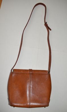 "Vintage cognac brown Cristian italian cognac Brown Florence Leather crossbody bag/shoulder bag. Footed rustic boho handBag with Shoulder Strap. Inside 1 zip compartment. Magnetic frontal closure. Inside bag cover has cracks - look at the photo. Inside brown textile lining. From 1970s. Adjustable strap. Inside label with inscription: Cristian, Florence leather, made in Italy. brand: Cristian. condition: The purse has many streaks/scratches on the surface. Shabby purse. Measurements: height 20,5 Brown Saddle Shoulder Bag With Leather Handles, Brown Leather Handle Saddle Shoulder Bag, Vintage Light Brown Satchel Shoulder Bag, Brown Saddle Shoulder Bag, Vintage Light Brown Satchel With Adjustable Strap, Brown Saddle Shoulder Bag For Travel, Vintage Cognac Satchel With Adjustable Strap, Classic Brown Crossbody Hobo Bag, Vintage Saddle Shoulder Bag With Adjustable Strap