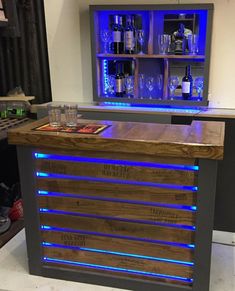 a bar made out of pallet wood with blue lights on the top and bottom