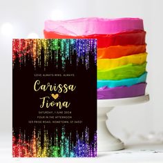 a cake with rainbow icing on it next to a card