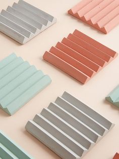 many different colors of wooden slats arranged on a table with white and pink walls