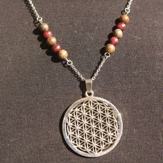 "Discover a Flower of life energy healing cristals necklaces for women or men.  This Inspirational necklace is associated with gemstones Grade A to allow us to rebalance, harmonize us. This Flower of life spiritual pendant is in alloy, it measures 40mm x 40 mm and the chains is in stainless steel.  Personalized your meditation jewelry with different lengths your choice.  This sacred geometry jewelry is the perfect talisman gifts, meditation gift for her, birthday gift, friendship gift for him, amulet alchemic gift, inspirational gift.  Many spiritual meanings are associated with this geometrical figure. For some,it is seen as a symbol that depicts the cycle of creation, and as such it has been accepted by different cultures and religions as the model of God's creation.  S I Z E ~ G U I D E Holistic Jewelry With 108 Beads For Gift, Spiritual Round Pendant With Gemstone Beads, Spiritual Jewelry With Round Gemstone Pendant, Spiritual Round Pendant Necklace For Meditation, Symbolic Gemstone Beads Jewelry For Meditation, Symbolic Natural Stone Pendant Necklace, Spiritual Nickel-free Pendant Necklace, Nickel-free Spiritual Pendant Necklace, Symbolic Gemstone Bead Necklaces For Gifts