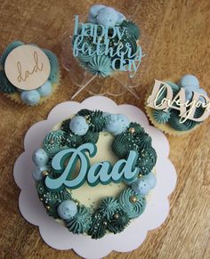 two cupcakes with the word dad written in frosting on them and some decorations