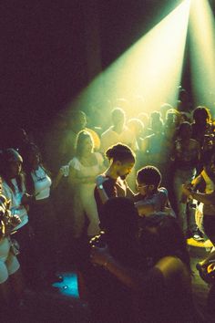 a group of people standing around each other in front of a crowd at a concert