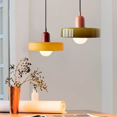 three different colored lights hanging over a table