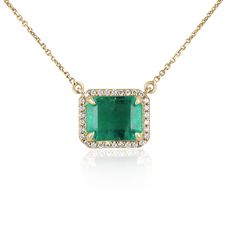 Featured here is a stunning statement size East to West rich bluish green emerald and round diamond halo necklace handmade in fine 14K yellow gold. Displayed is a lustrous, medium-rich green with very good transparency, accented by a simple secure four-prong 14K mount, allowing for the gorgeous large emerald to be shown in full view. Brilliant round natural diamonds halo sparkle around the emerald. The chain is stationary and is an adjustable 18-16 inch long necklace to easily wear in different Luxury Brilliant Cut Emerald Diamond Necklace, Luxury Gold Baguette Cut Emerald Necklace, Luxury Faceted Yellow Gold Emerald Necklace, Round Diamond Halo, Green Stone Pendant, Slider Necklace, Emerald Style, Gold Slides, Pear Pendant