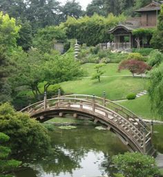 a wooden bridge over a small pond in a park