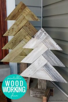 three wooden christmas trees sitting next to each other on top of pallet boards in front of a house