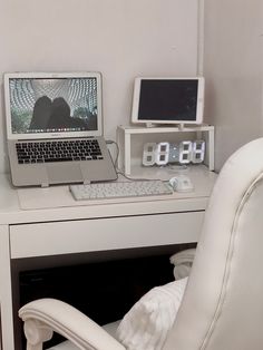 a white desk with a laptop and monitor on it