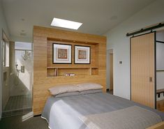 a bed sitting in a bedroom next to a sliding glass door with two pictures on the wall