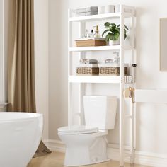 a white toilet sitting in a bathroom next to a bathtub and shelf filled with items