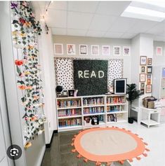 the room has many bookshelves and pictures on the wall, along with a round rug