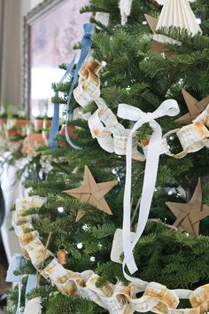 a decorated christmas tree with star decorations on it's branches and ribbons hanging from the top