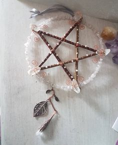 a star made out of beads and other items on a white tablecloth with purple flowers