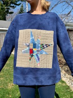 Unique, blue sweatshirt (New) with quilted square appliqué. This is a one-of-a-kind shirt. Quilt appliqué is fashioned out of gorgeous striped, plaid and tie-dyed fabrics creating a unique star pattern.  Shirt itself is blue on blue tie-dye. Sweatshirt is super soft and cozy - Perfect for the breeze coming off the lake or that evening pontoon boat ride.  Women's sized SMALL. Casual Long Sleeve Quilted Top, Blue Cotton Patchwork Tops, Casual Crew Neck Sweatshirt With Patches, Blue Patchwork Sweatshirt For Fall, Hand Dyed Long Sleeve Blue Sweatshirt, Hand Dyed Blue Long Sleeve Sweatshirt, Hand Dyed Blue Cotton Sweatshirt, Cotton Sweatshirt With Patchwork In Relaxed Fit, Blue Hand Dyed Cotton Sweatshirt