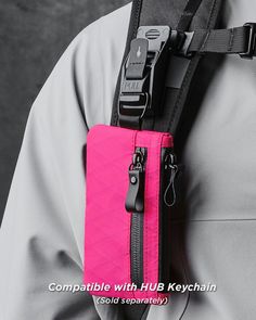 a person wearing a pink and black belted waist bag with zippers on it