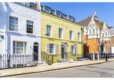 several different colored houses line the street in front of each other