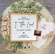 a baby's first birthday gift set up on top of a wooden table with greenery