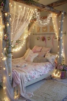 a bed with lights on the headboard and canopy over it, in a bedroom