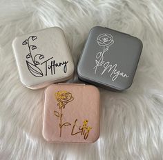 three small tins with designs on them sitting on a white furnishing surface