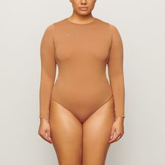 A second-skin crew neck long sleeve bodysuit with an ultra-flattering satin stretch finish. This bodysuit features a raw cut neckline, and snap closure at base. Long Sleeve Stretch Bodysuit With Smoothing Details, Long Sleeve Second-skin Smoothing Bodysuit, Sleek Long Sleeve Second-skin Leotard, Stretch Stitch, Mock Neck Bodysuit, 7 Jeans, Mock Neck Long Sleeve, Versatile Wardrobe, Stretch Satin