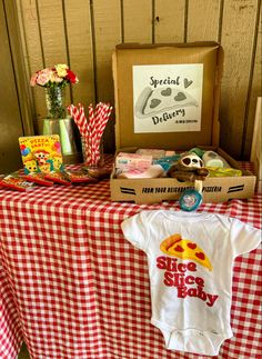 a red and white checkered table cloth topped with an infant's bodysuit