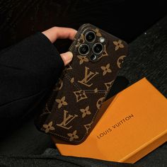 someone is holding their louis vuitton iphone case in their hand and it's inside an orange box