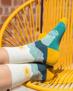 Peak Experience Organic Cotton Socks by Happy Earth It's all about the climb in these mountain-themed socks. Teals, beiges, and blues make up this scene, highlighted by a golden sun, heel, and toe. Soft, supportive socks made to put your best foot forward! Knit from comfy, breathable organic cotton with a touch of recycled nylon and elastane to enhance flexibility and moisture-wicking performance. Soft, breathable organic cotton Cushioned foot and arch support Reinforced toe and heel "Happy Eart Socks Illustration, Socks Photography, Organic Dress, Trendy Socks, Sock Outfits, Golden Sun, Soft Sock, Happy Earth, Crazy Socks