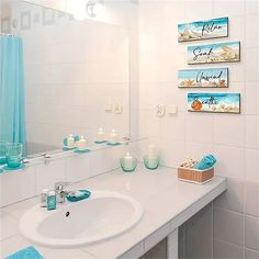 a bathroom sink with blue towels and candles on the counter