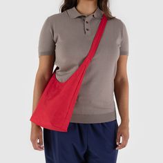 Aesthetically minimal yet functionally versatile, the Baggu Recycled Nylon Sling Bag is  perfect when you don't need a lot. Wear this style over the shoulder or crossbody on hikes, at concerts, and for quick errands. It has a long adjustable strap, an interior pocket,  as well as a magnetic closure for easy access to your everyday essentials. Emily Sugihara started Baggu in 2007 because she sought a more sustainable alternative to traditional disposable grocery bags. Since then, the San Francisco-based company has become well-known for functional, affordable and nice-looking products. Small Sling Bag, Candy Apple Red, Candy Apple, Candy Apples, Nylon Bag, Red Apple, Art Clothes, Sling Bag, Magnetic Closure