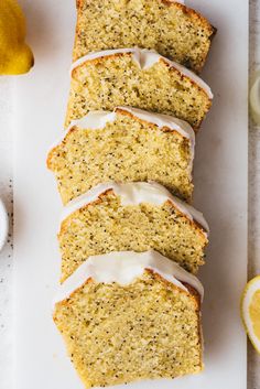 slices of lemon poppy seed bread with icing on a cutting board next to sliced lemons