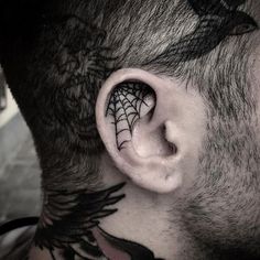 a man with a spider web tattoo on his ear