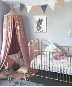 a baby's room is decorated with pink and gold accents, including a canopy bed