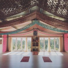 a large room with lots of windows and rugs on the floor